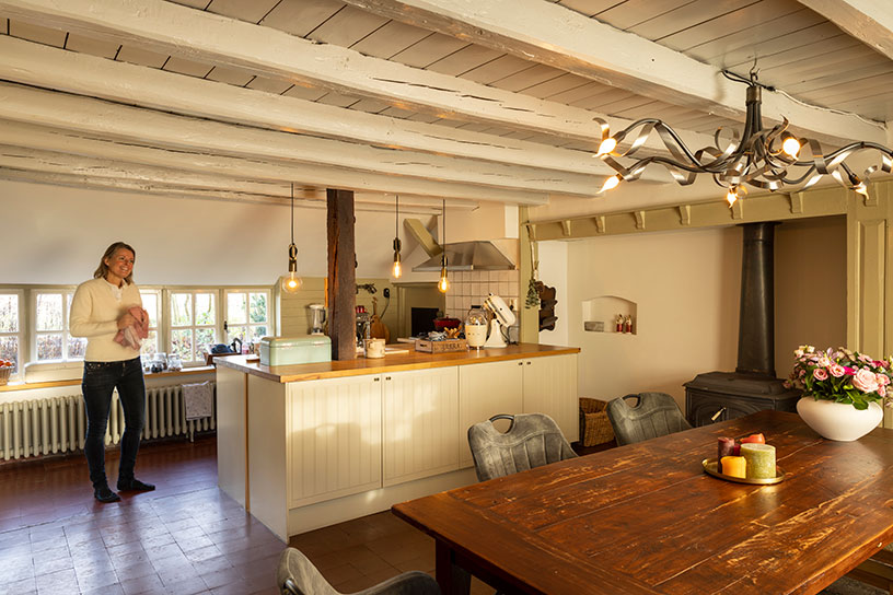 Met fris geschilderde plafonds en doorgebroken muren is een lichte, gezellige woonkeuken gecreëerd.